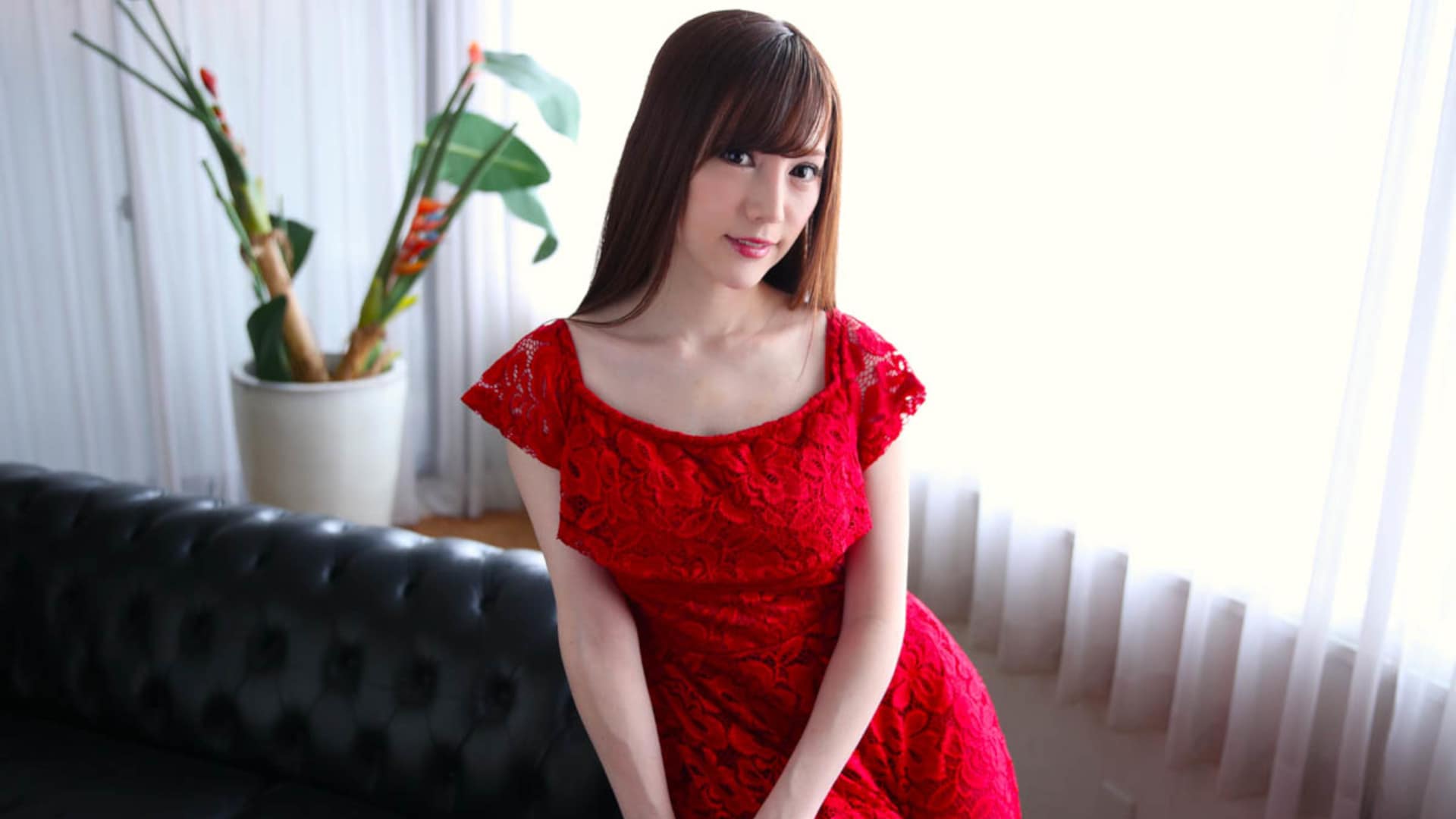 Brunette sexy Asian model posing on sofa